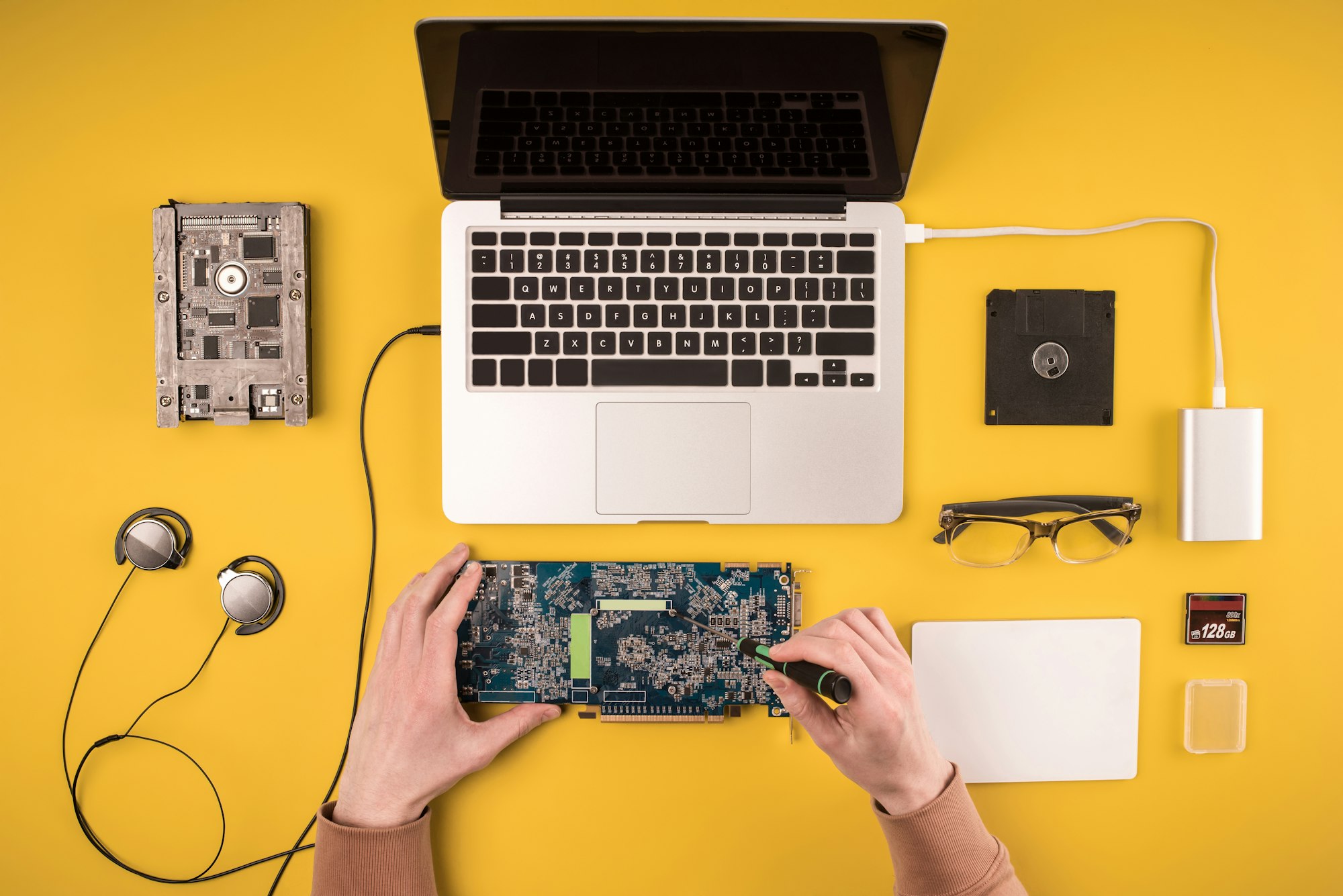 partial top view of person fixing laptop on yellow